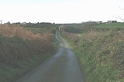 Country road approaching Penterfyn Cottage, with the village of Engedi in the background - geograph.org.uk - 1068503.jpg