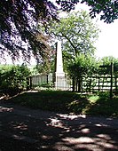 Memorial obelisk in roadside field.