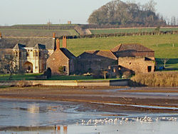 Stone buildings with water in front.